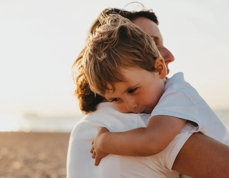 A parent holding a young child close