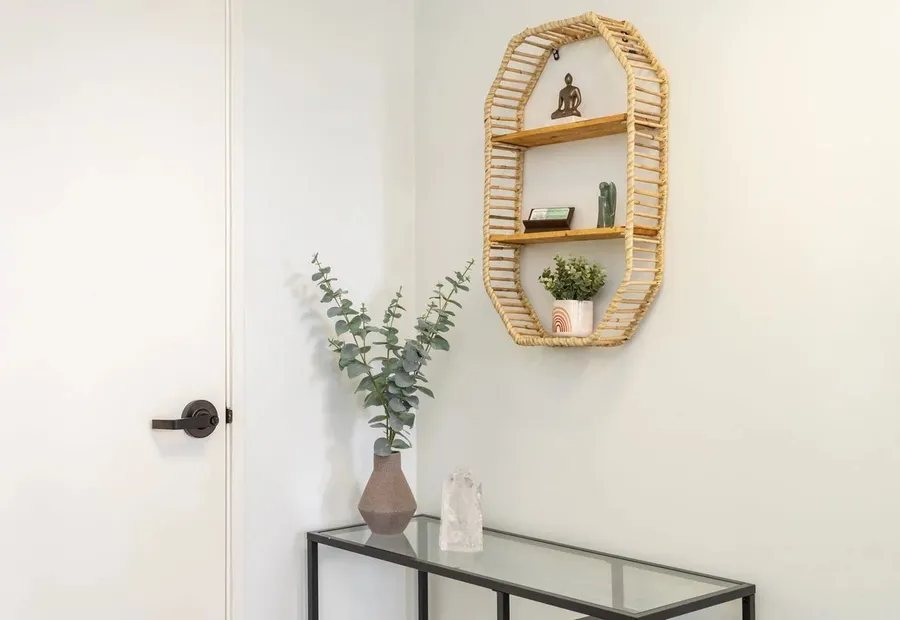 Entry with a wooden wall shelf, a plant and a glass console table