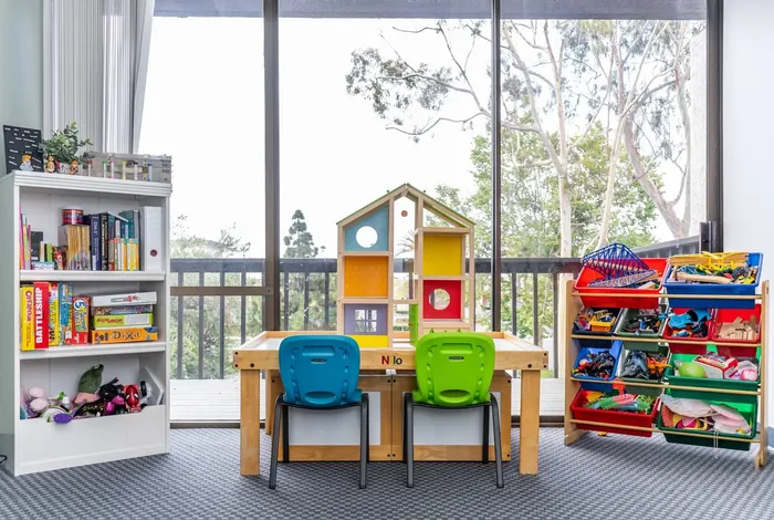 A play room at Insight with bookshelves, small tables and a view of the trees