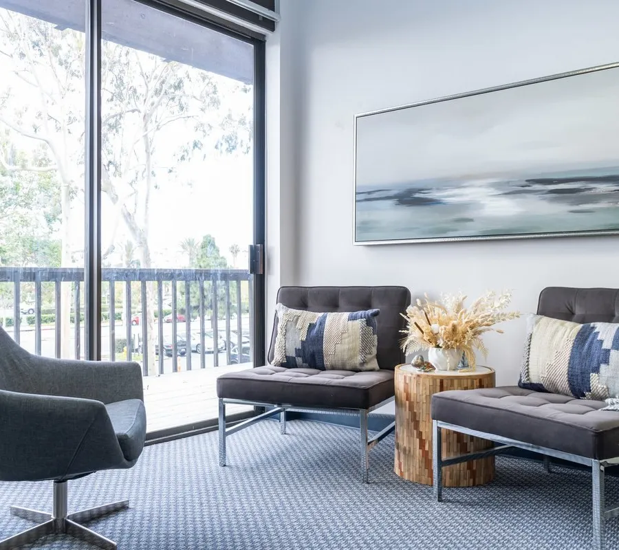 The waiting area at Insight with armchairs, calm artwork and a view of the trees