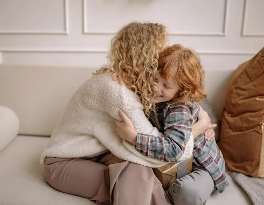 A parent and child sharing a close moment on the couch