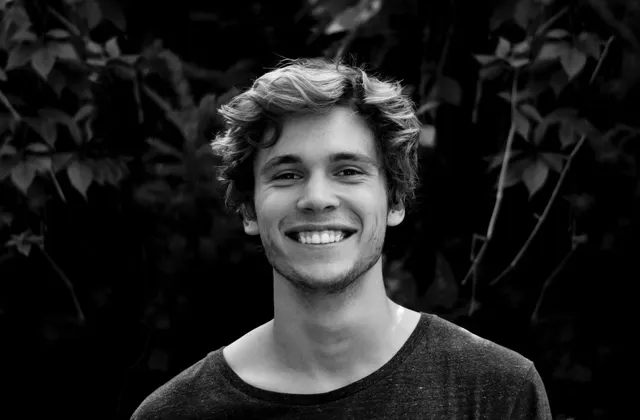 A young adult smiling outdoors