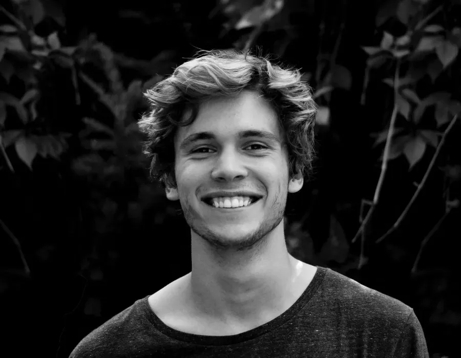 A young adult smiling outdoors